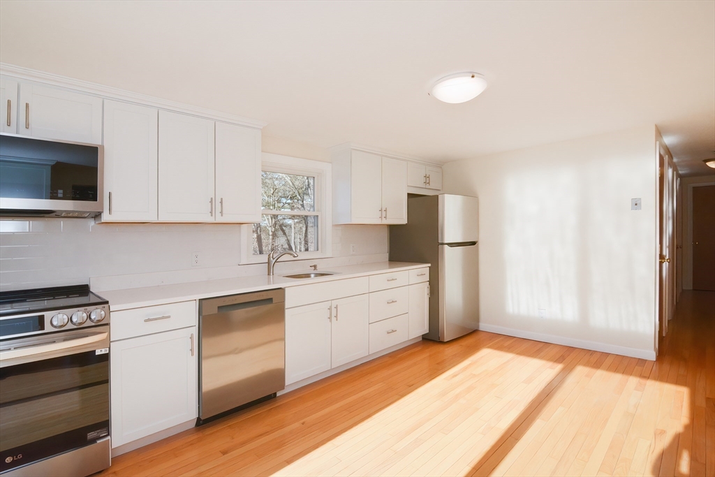 25 Indian Run Road Bellingham, MA 02019 - Photo 8 of 29 a kitchen with stainless steel appliances white cabinets and a refrigerator