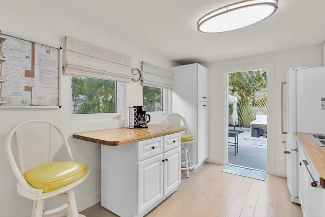 a kitchen with a sink a stove a refrigerator a dining table and chairs