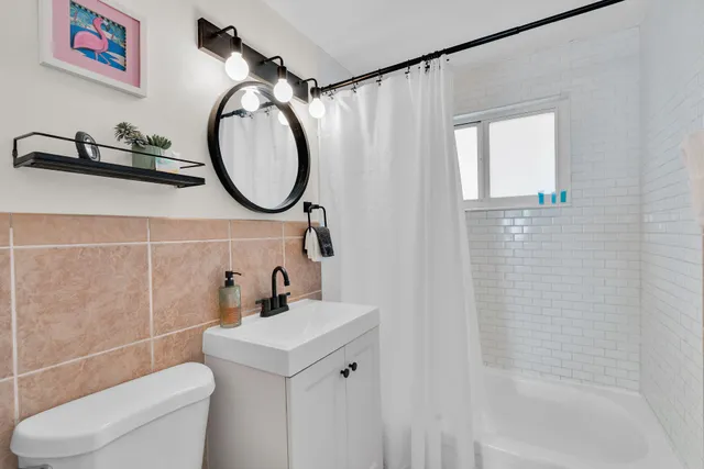a bathroom with a toilet a sink and a mirror
