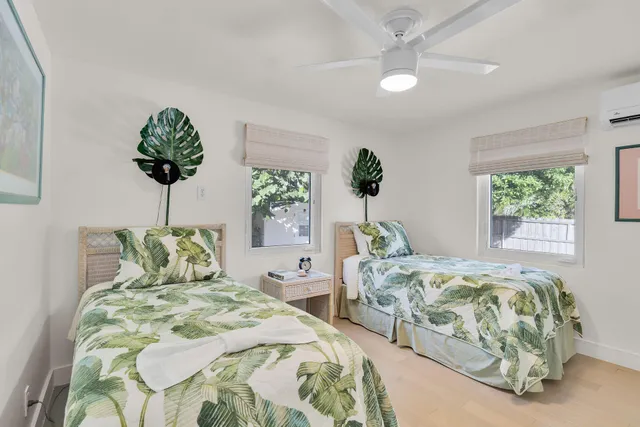 a bedroom with two beds and a potted plant