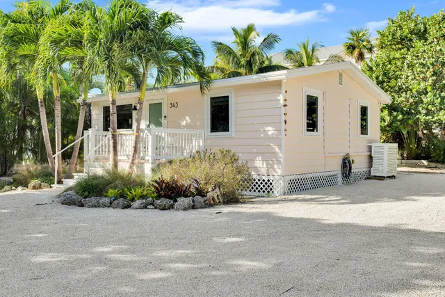 a front view of a house with a yard and potted plants
