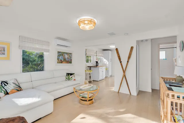 a living room with furniture a wooden floor and a large window