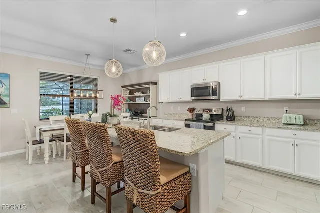 a kitchen with stainless steel appliances granite countertop a stove a sink dishwasher a dining table and chairs with wooden floor