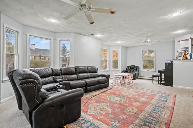 a living room with furniture a large window and gym equipment