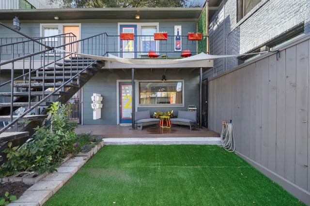 a view of a chair and table in the back yard of the house
