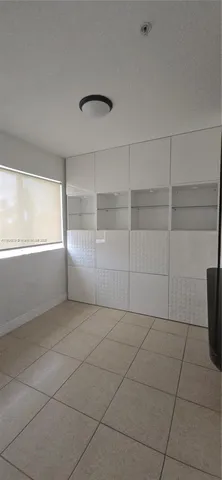 a view of a livingroom with an empty space and a window