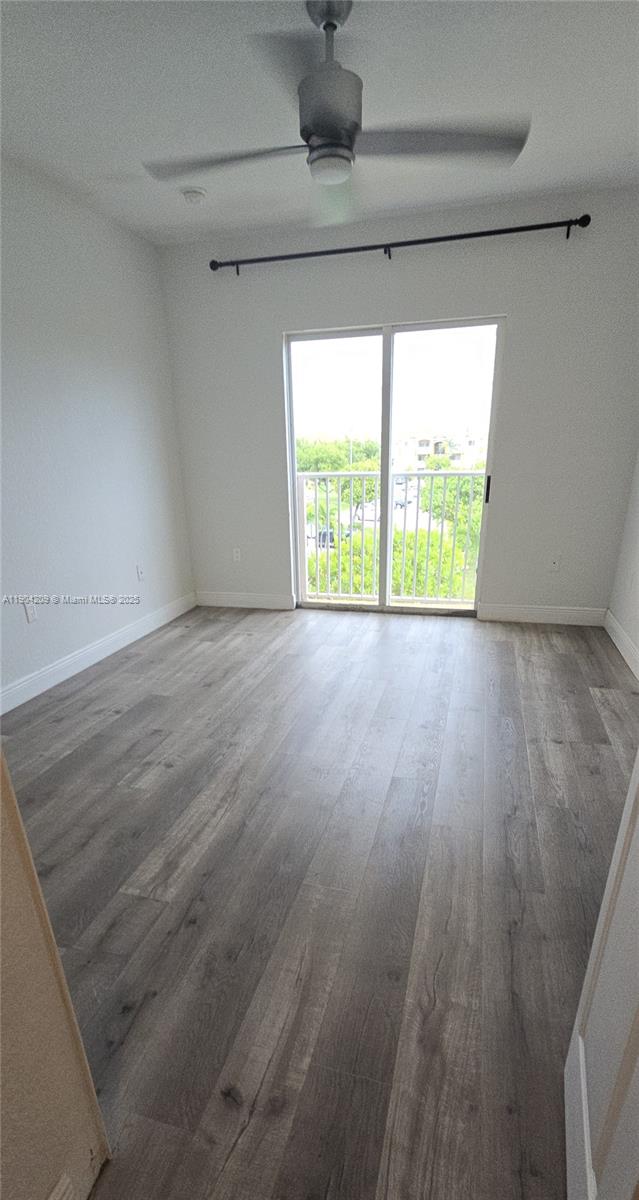 21000 Southwest 87th Avenue, Unit 308 Cutler Bay, FL 33189 - Photo 19 of 30 a view of an empty room with wooden floor and a window