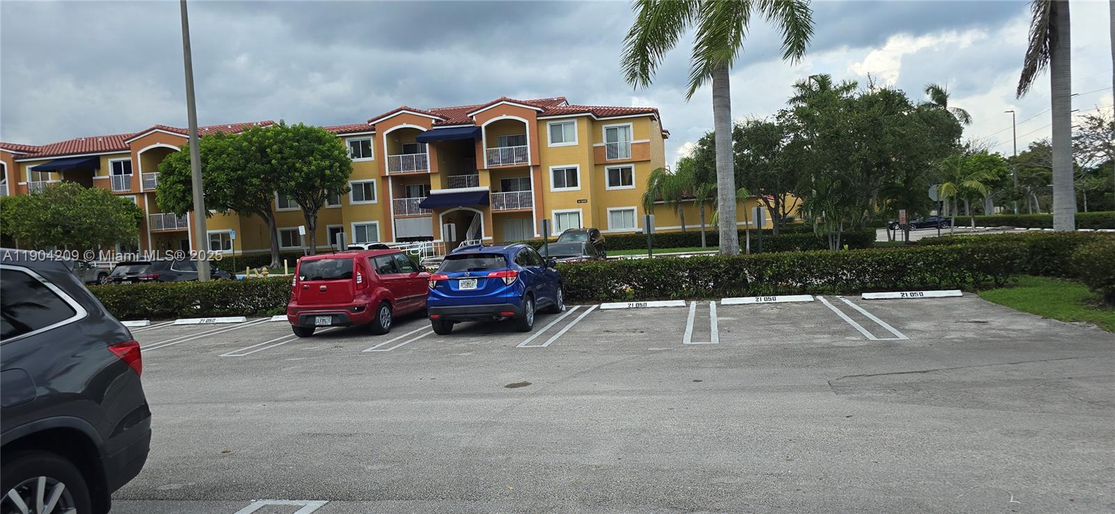 21000 Southwest 87th Avenue, Unit 308 Cutler Bay, FL 33189 - Photo 29 of 30 a view of a cars park in front of a brick house
