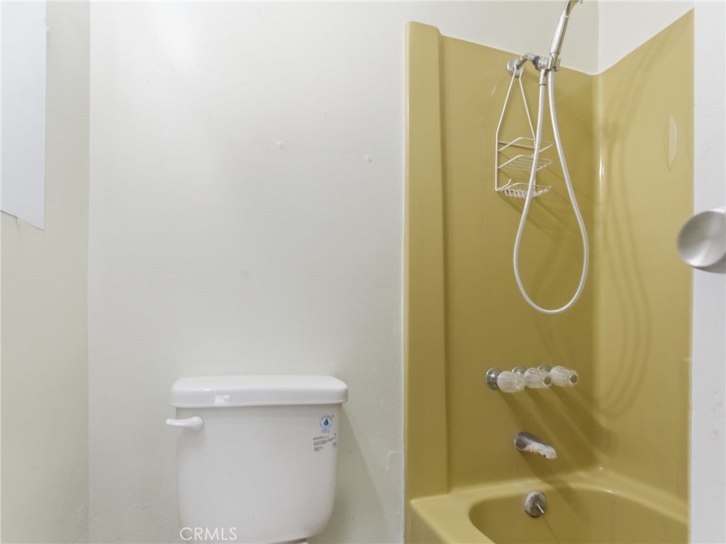 10127 Foothill Boulevard Sylmar, CA 91342 - Photo 16 of 33 a bathroom with a shower and a toilet