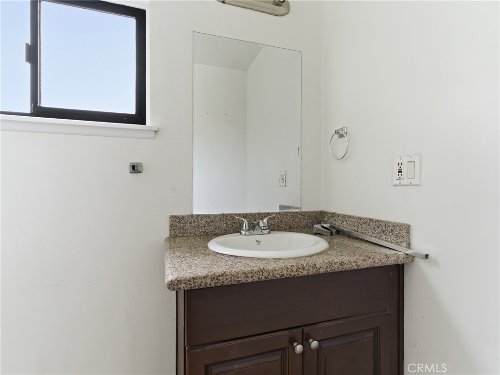 10127 Foothill Boulevard Sylmar, CA 91342 - Photo 22 of 33 a bathroom with a granite countertop sink and a mirror