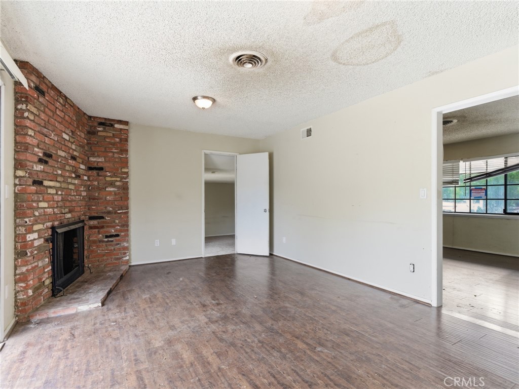 10127 Foothill Boulevard Sylmar, CA 91342 - Photo 5 of 33 wooden floor in an empty room with a fireplace