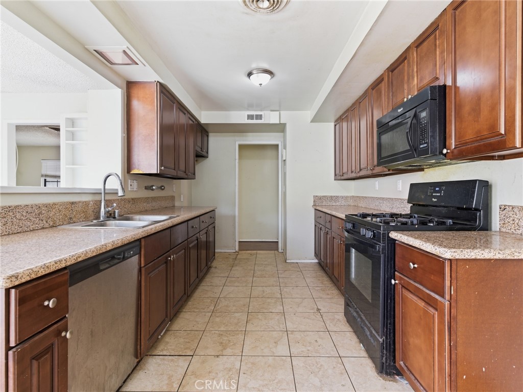 10127 Foothill Boulevard Sylmar, CA 91342 - Photo 6 of 33 a large kitchen with stainless steel appliances granite countertop a stove a sink and a microwave