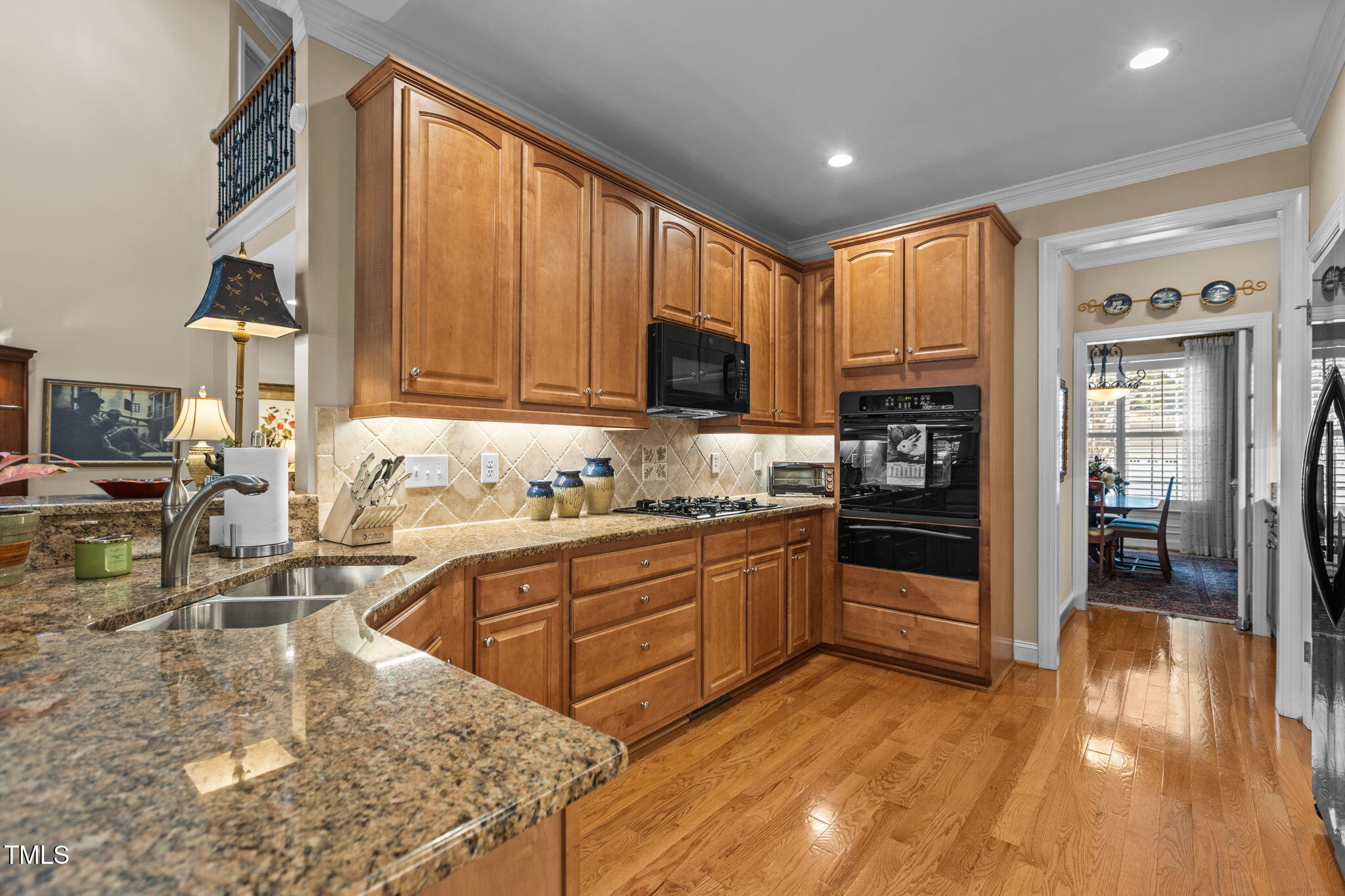 206 Nouveau Avenue Raleigh, NC 27615 - Photo 25 of 61 a kitchen with stainless steel appliances granite countertop a refrigerator a stove and a sink with wooden floor