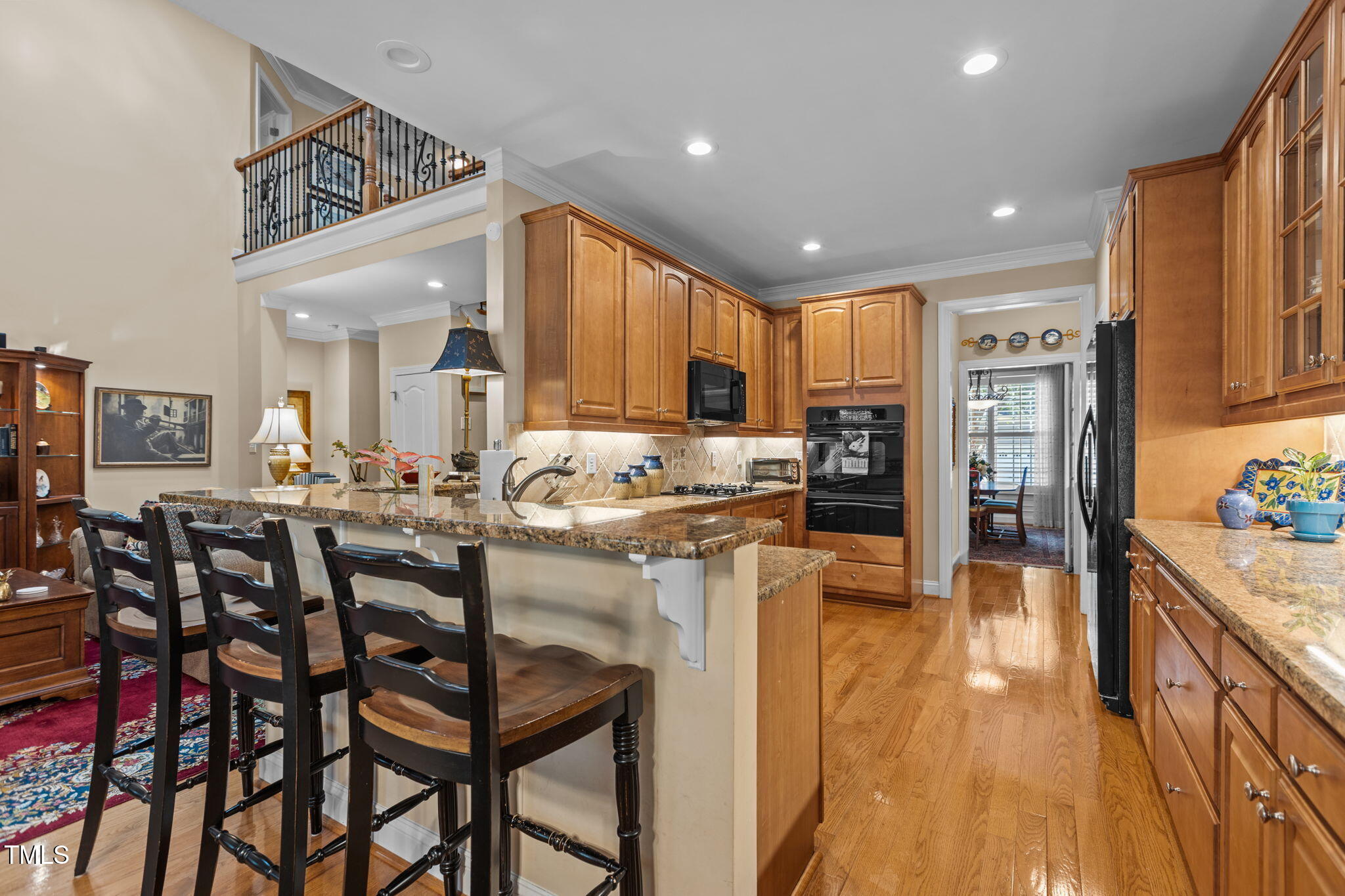 206 Nouveau Avenue Raleigh, NC 27615 - Photo 26 of 61 a kitchen with stainless steel appliances kitchen island granite countertop a table chairs refrigerator and sink