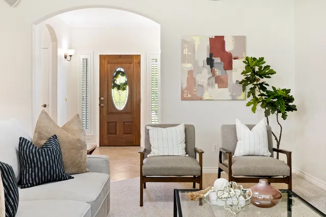 a living room with furniture flowerpot and wooden floor