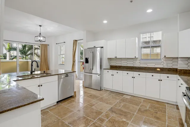 a large white kitchen with a stove a sink dishwasher and a refrigerator