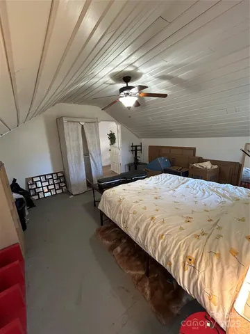 a large bed sitting in a bedroom next to a chandelier
