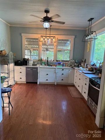 a large kitchen with a large window a counter space and stainless steel appliances