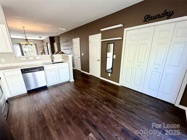 a large white kitchen with wooden floor