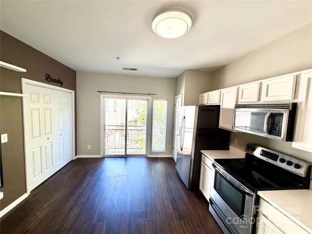 a kitchen with stainless steel appliances a stove microwave and wooden floor