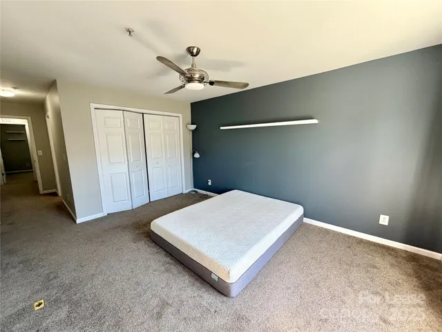 a bedroom with a bed and a ceiling fan
