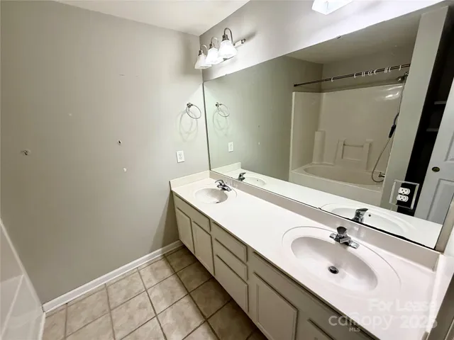 a bathroom with a double vanity sink and a mirror
