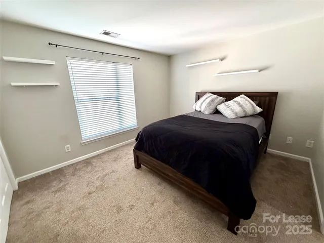 a spacious bedroom with a bed and a window
