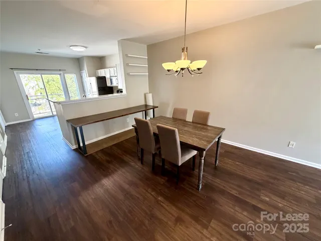 a view of a dining room with furniture wooden floor and chandelier