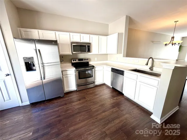 a kitchen with stainless steel appliances a stove a sink and a refrigerator