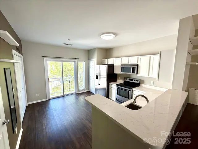 a kitchen with kitchen island a counter top space appliances and a window