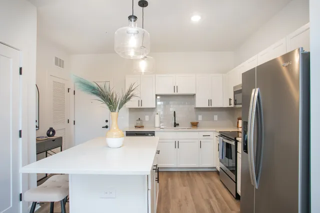 a kitchen with stainless steel appliances a sink stove and refrigerator