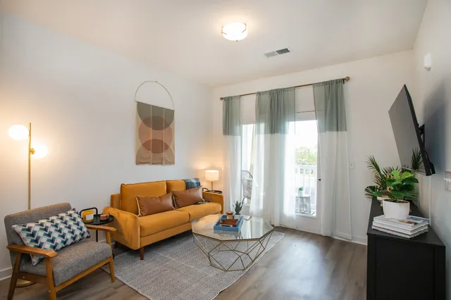 a living room with furniture and wooden floor