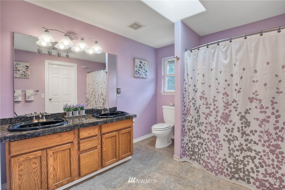 2516 Harts Lake Road South Roy, WA 98580 - Photo 19 of 32 a bathroom with a granite countertop sink a toilet a mirror and shower
