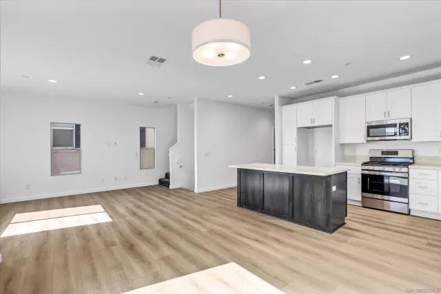 a kitchen with stainless steel appliances granite countertop a stove a sink and a refrigerator