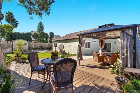 a view of a house with backyard and sitting area
