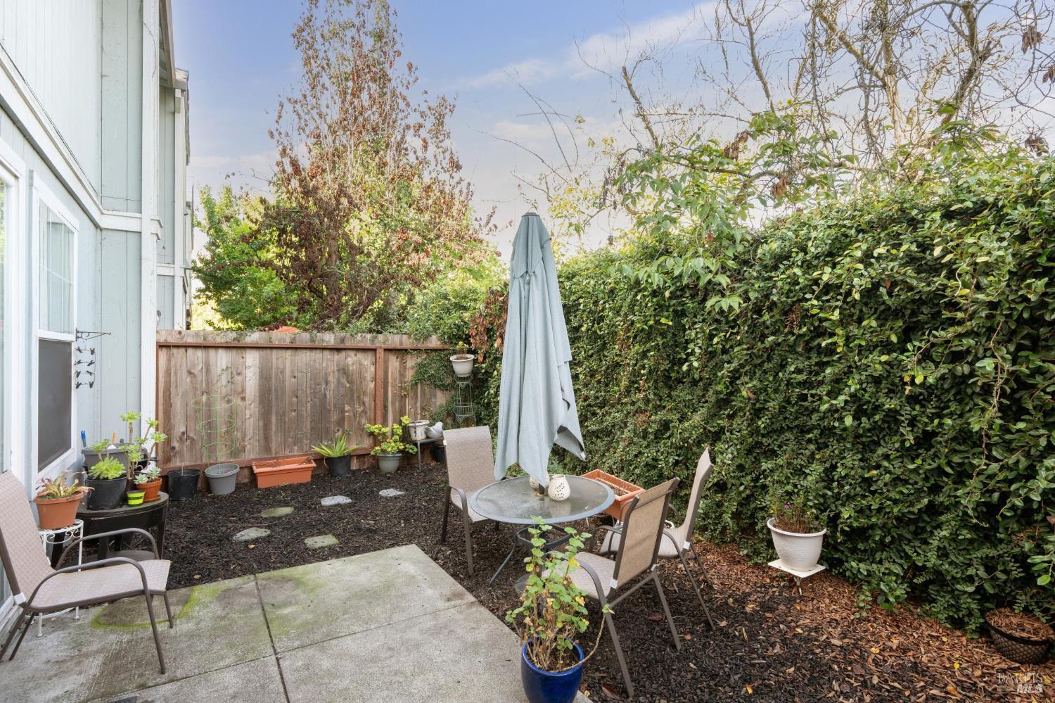 1507 Pinebrook Place Santa Rosa, CA 95403 - Photo 14 of 15 a view of a patio with table and chairs potted plants and wooden fence