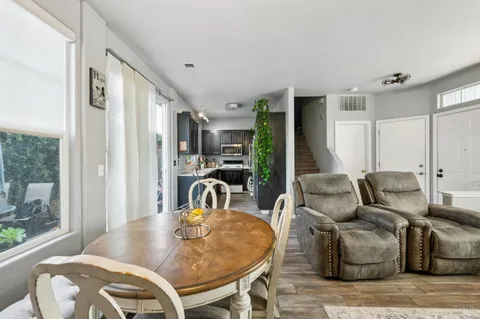 a living room with furniture a large window and wooden floor