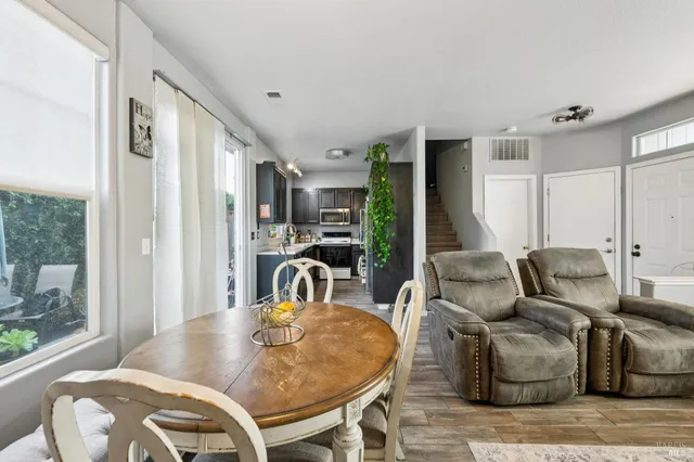a living room with furniture a large window and wooden floor