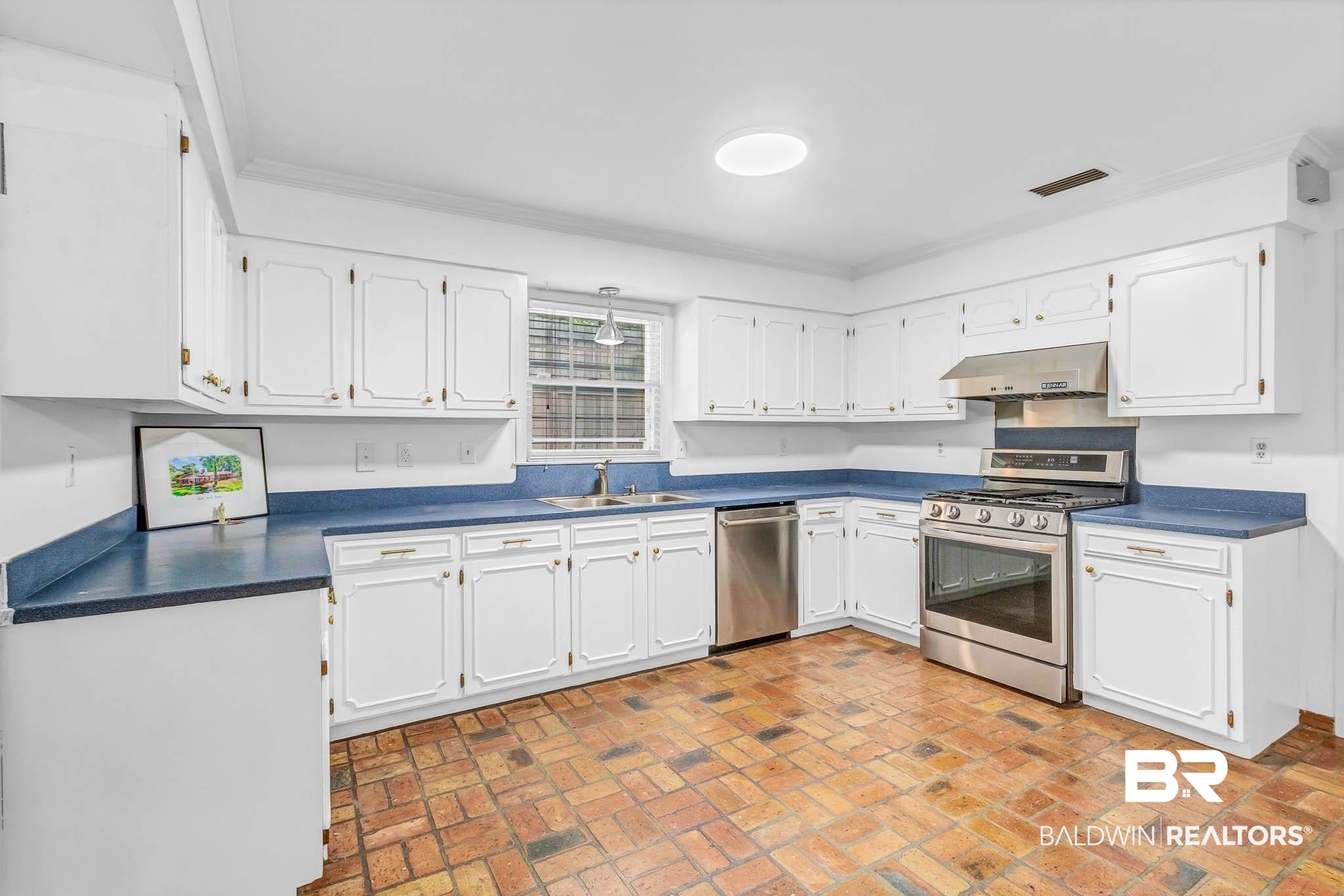 309 West Brandy Run Road Mobile, AL 36608 - Photo 20 of 100 Kitchen with dark countertops, appliances with stainless steel finishes, brick flooring, white cabinets, and range hood
