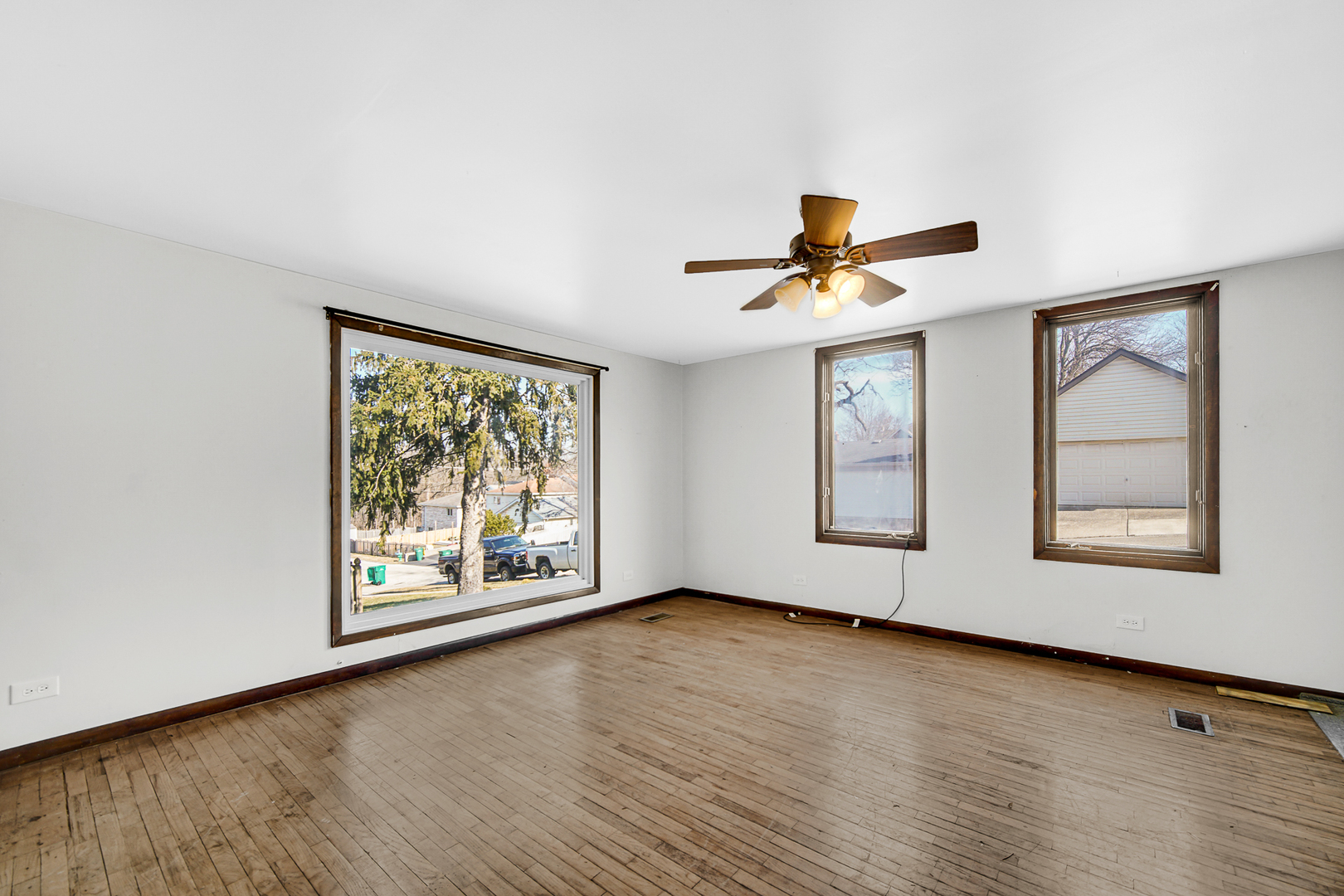 716 Chestnut Street Lemont, IL 60439 - Photo 6 of 20 an empty room with wooden floor chandelier and windows