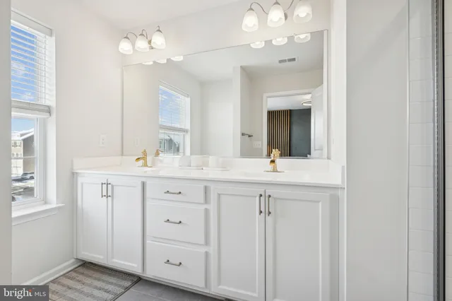 a bathroom with a double vanity sink and a mirror