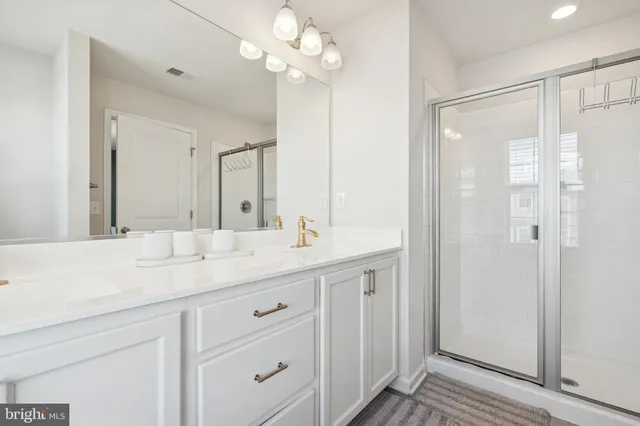 a bathroom with a granite countertop sink a mirror and a shower