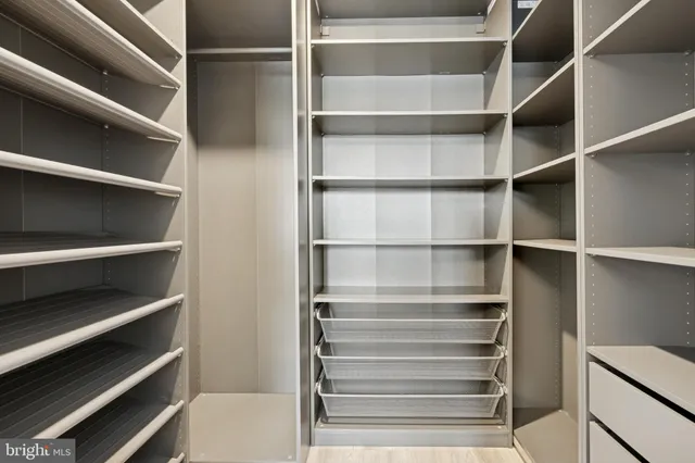 a view of walk in closet with empty racks
