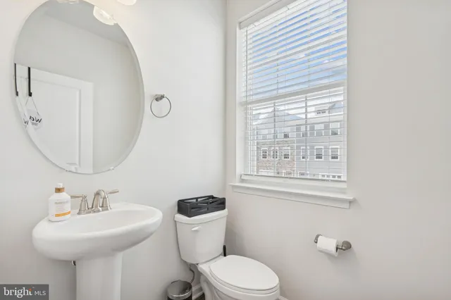 a bathroom with a toilet a sink and mirror