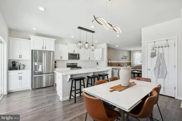 a open kitchen with refrigerator cabinets dining table and chairs
