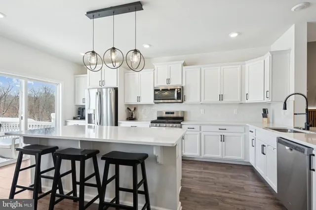 a kitchen with a table chairs cabinets a stove and a window