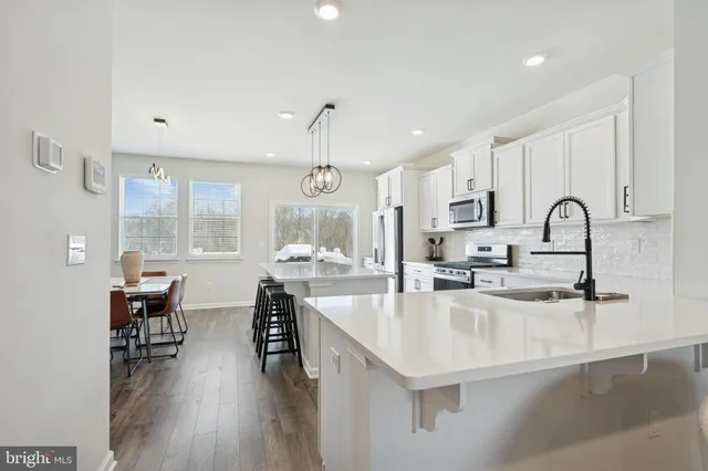 a kitchen with kitchen island granite countertop a sink cabinets and wooden floor