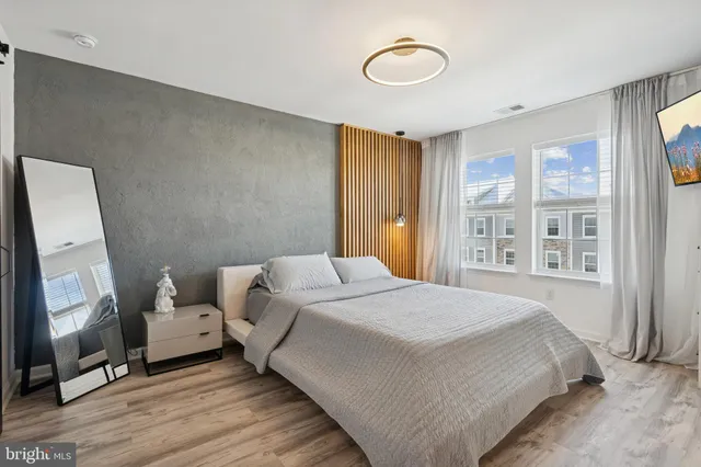 a bedroom with a bed a mirror and a window