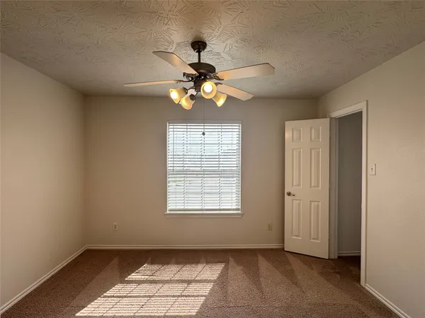 an empty room with a ceiling fan and a closet