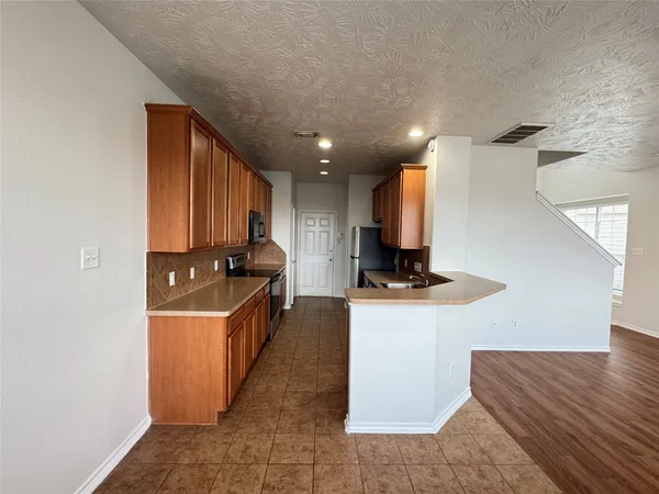 a kitchen with stainless steel appliances granite countertop a sink a stove and a refrigerator